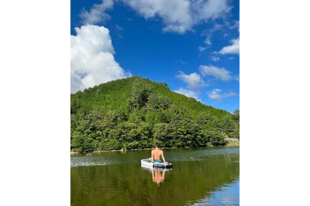 湖でボートに乗る男性の後ろ姿の写真